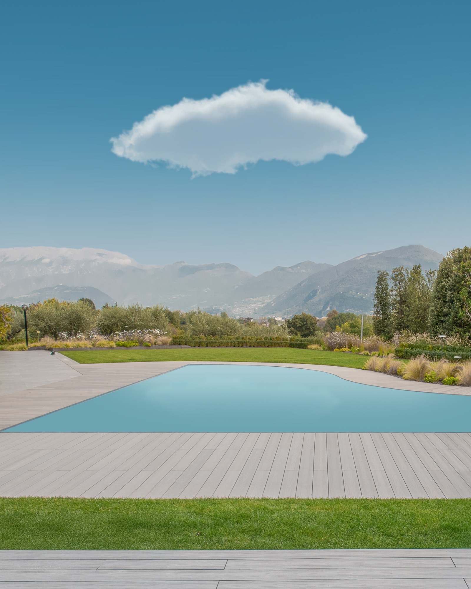 Una nuvola sospesa sopra una piscina, davanti alle montagne
